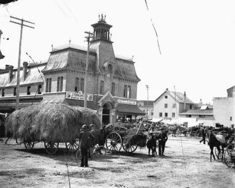 The James Mather-designed ByWard Market building with vendors and horse-drawn wagons.
